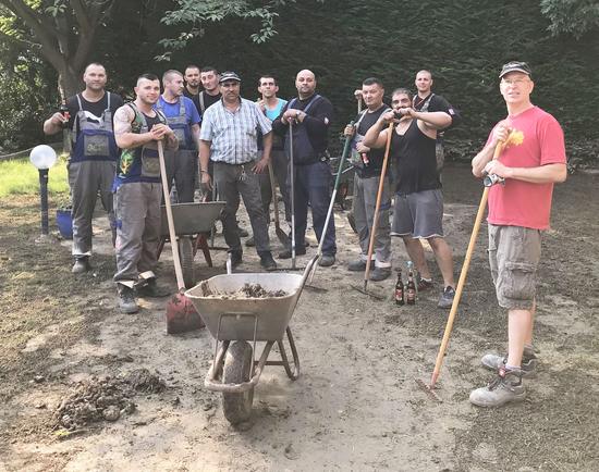 Widdigs Ortsvorsteher Christoph Kanymit Monteuren aus Ungarn, die nach ihrer Schicht geholfen haben, am Schwadorfer Kreuz Vorgärten von Schlamm zu befreien