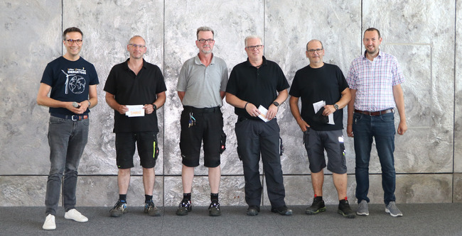 Als Dankeschön erhielten die Hausmeister von Thorsten Schmidt, Geschäftsführer der Energieagentur Rhein-Sieg (l.), ein Brillenputztuch mit Aufschrift "Schlau Unterwegs"