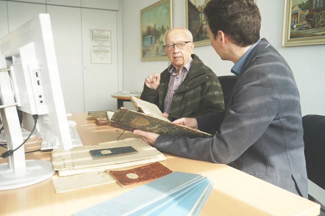 Stadtarchivar Dr. Oelgemoeller (vorne) und Heimatforscher Geuer sichten die historischen Dokumente