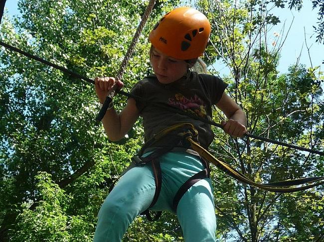 Kind klettert im Klettergarten