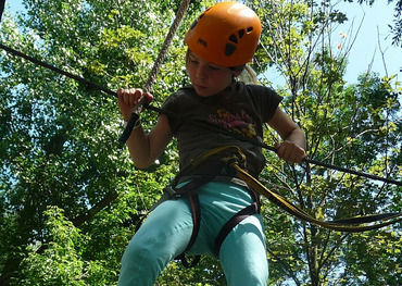 Kind klettert im Klettergarten