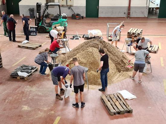 Helfer befüllen Sandsäcke beim Stadtbetrieb Bornheim