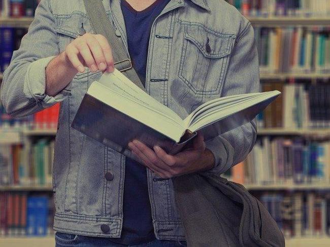 Ein Student liest ein Buch in der Bücherei