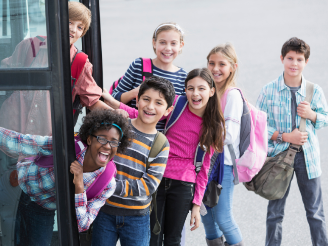 Die Kids steigen freudig in den Schulbus ein